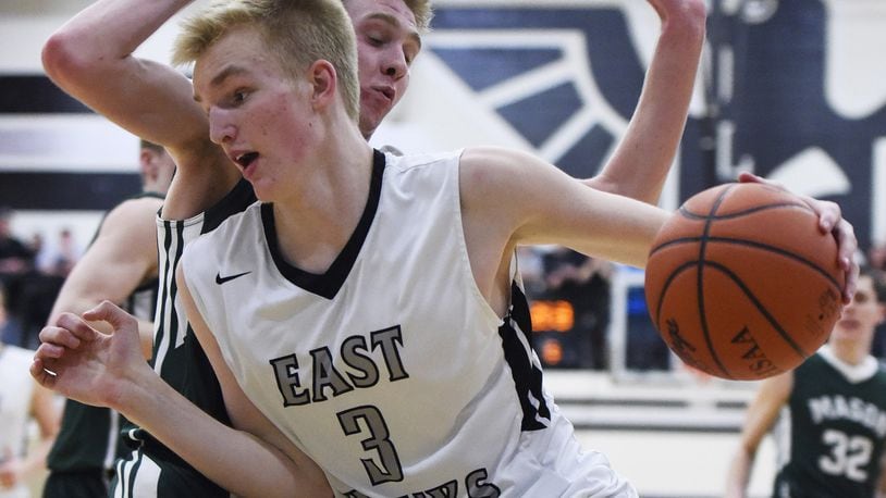 Lakota East’s Adam Dieball dribbles under the basket while being guarded by Mason’s Matt King on Feb. 20, 2015, at East. The host Thunderhawks won 63-62 in overtime. NICK GRAHAM/STAFF
