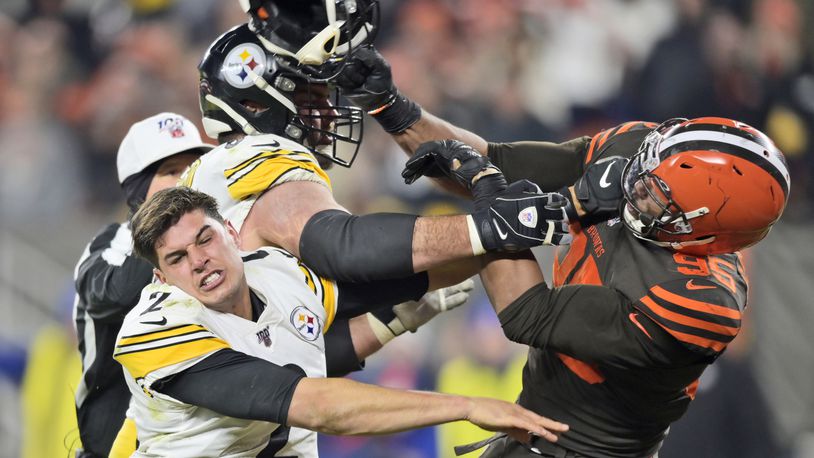 Cleveland Browns defensive end Myles Garrett (95) hits Pittsburgh Steelers quarterback Mason Rudolph (2) with a helmet during the second half of an NFL football game Thursday, Nov. 14, 2019, in Cleveland. (AP Photo/David Richard)