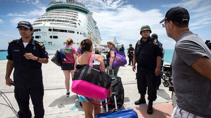 This photo provided by the Dutch Defense Ministry on Sunday, Sept. 10, 2017, shows people walking toward a cruise ship anchored on St. Maarten, after the passage of Hurricane Irma. Irma cut a path of devastation across the northern Caribbean, including this island that is split between French and Dutch control. (Gerben Van Es/Dutch Defense Ministry via AP)