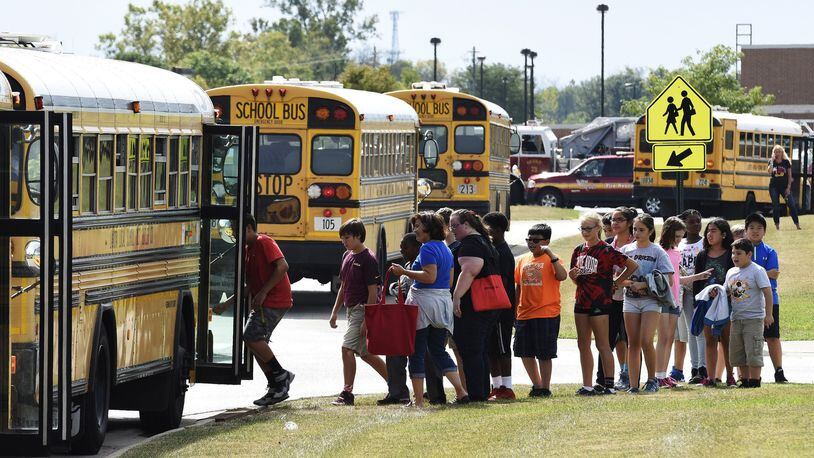 Endeavor Elementary School students line up to get on a bus to be transported to Lakota West Freshman School after a bomb threat was called in forcing the school to be evacuated Friday, Sept 25. A bomb sniffing dog from the Miami University Police department was called to the scene and searched and cleared the building. NICK GRAHAM/STAFF