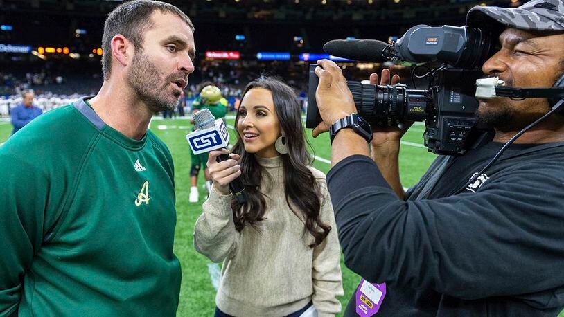 In this Dec. 14, 2019, photo Acadiana head coach Matt McCullough, left, speaks with Carley McCord, center, following a win over the Destrehan in the State Division 5A Championship football game in Lafayette, La. (Scott Clause/The Daily Advertiser via AP)