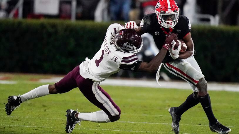 FILE -Mississippi State cornerback Martin Emerson, left, tackles Georgia wide receiver George Pickens during the first half of an NCAA college football game Saturday, Nov. 21, 2020, in Athens, Ga. Georgia wide receiver George Pickens still has a chance to be a major contributor for the Bulldogs this season. The junior who was expected to be third-ranked Georgia's go-to receiver before he tore the ACL in his right knee during spring practice will be available Friday, Dec. 31, 2021 for the College Football Playoff semifinal at the Orange Bowl against No. 2 Michigan. (AP Photo/Brynn Anderson, File)