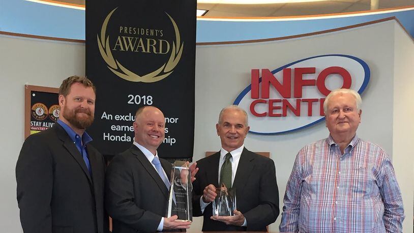L to R: Brad Voss, Craig Voss, Roger Quant and John Voss celebrate Voss Honda s win of Honda President s Award for 2018, the 20th consecutive time the Tipp City dealership has achieved such a distinction. AMY ROLLINS/STAFF