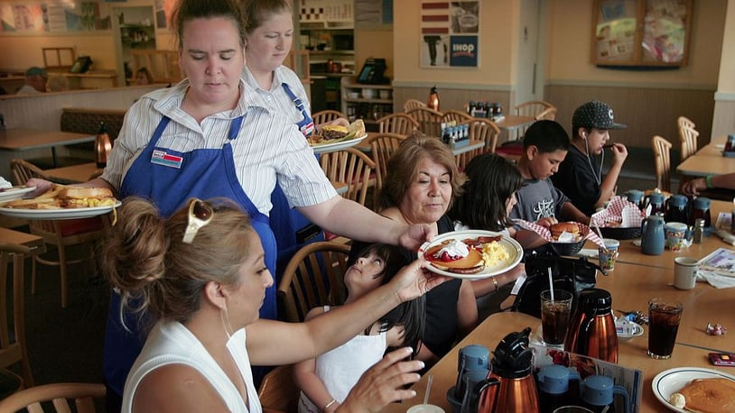 Waitresses Gretchen Boren (L) and Michelle Enright wait on customers at an IHOP restaurant July 16, 2007 in Elgin, Illinois. (Photo by Scott Olson/Getty Images)