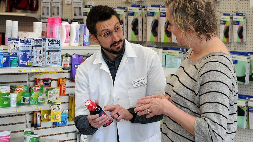 Cedar Care Village Pharmacy Pharmacist Dr. Justin Coby talks with Lea Ann Anspach. Coby said some manufacturers are not going to comply with new price negotiations under Medicare, which could mean patients having to switch to different medications or pay out of pocket. MARSHALL GORBY\STAFF