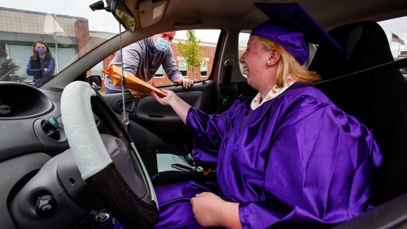 In May, Middletown High School graduates received their diplomas in a drive-by procedure that used coronavirus safe-distancing for the hand off to seniors in front of the school. School officials are now going to hold an in-person, but reduced crowd ceremony this Thursday outside at Barnitz Stadium. (Photo By Nick Graham/Journal-News)