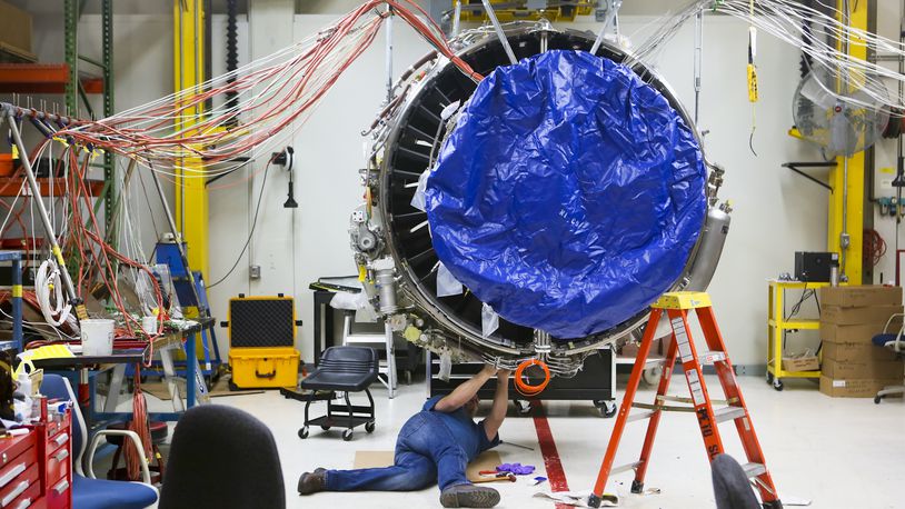 Engineers work on a LEAP commercial jet test engine at GE Aviation in Evendale, Friday, Dec. 19, 2014. The engine, made by CFM, a joint venture between GE and French  manufacturer Snecma, will be more fuel efficient and contain advanced materials, and will be transformative for the manufacturing industry because it will contain the first  mass-produced 3-D manufactured/additive component in a critical area. GREG LYNCH / STAFF