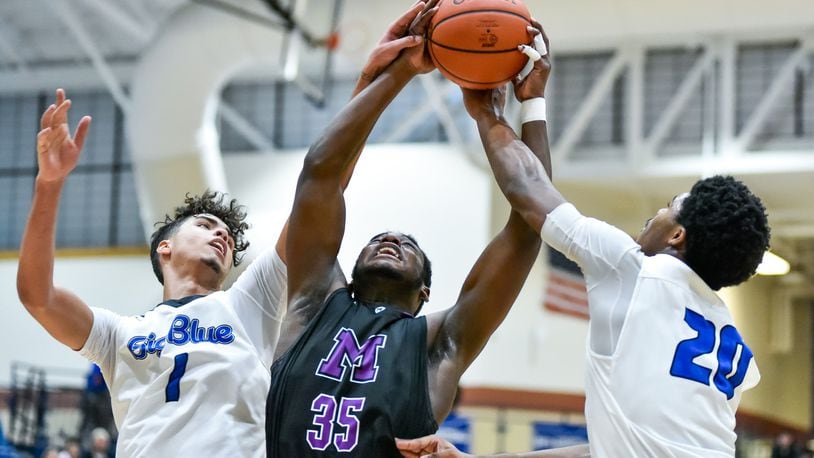 Middletown’s Jayden Burks, middle, battles for a rebound with Hamilton’s Trey Robinson, left, and Jayden Marshall during their game Friday, Jan. 3, 2020 at Hamilton High School. Hamilton Big Blue basketball defeated the Middletown Middies 41-38. NICK GRAHAM / STAFF