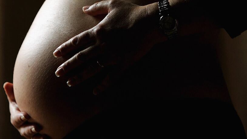 SYDNEY, NSW - JUNE 07:  A pregnant woman holds her stomach June 7, 2006 in Sydney, Australia. (Photo by Ian Waldie/Getty Images)