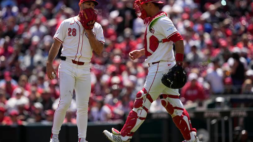 Cincinnati Reds starting pitcher Nick Martinez (28), and catcher Luke Maile (22) talk on the mound in the fifth inning of a baseball game against the Philadelphia Phillies on Thursday, April 25, 2024, in Cincinnati. The Phillies won 5-0. (AP Photo/Carolyn Kaster)