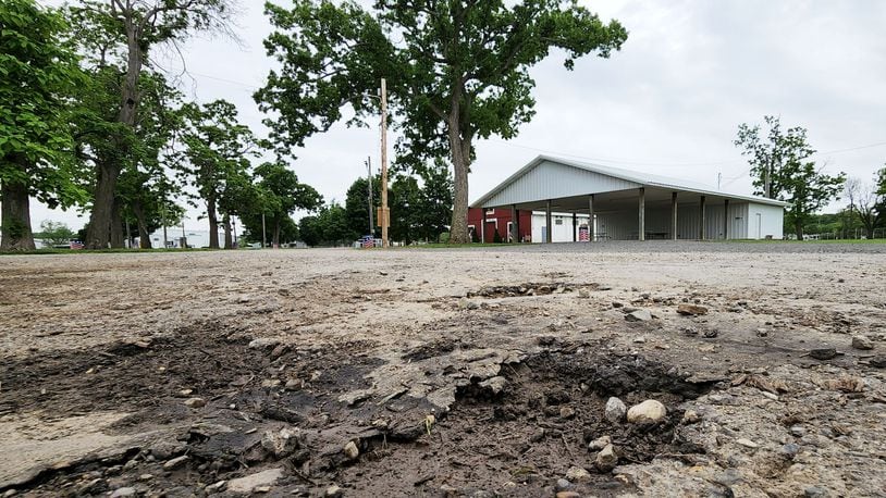 Numerous vehicles driving through during Covid-19 vaccine clinics caused some sections of asphalt to be damaged at Butler County Fairgrounds in Hamilton. Covid-19 relief funds could be used to pave areas of the fairgrounds. NICK GRAHAM/STAFF