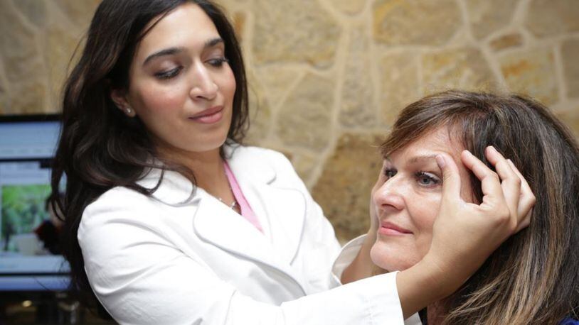 Dr. Amina Husain, eye surgeon with Premier Eye Surgeons, examines a patient.