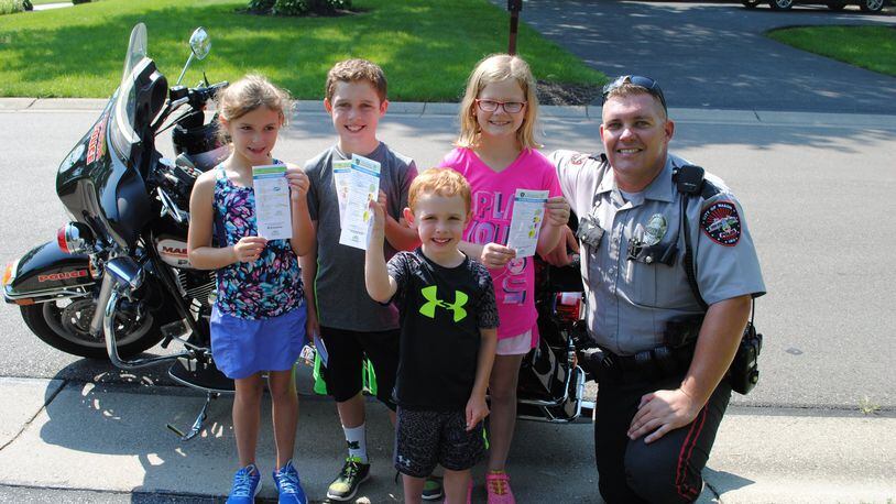 The City of Mason announced a new program called Good Choices Youth Recognition, which consists of City of Mason police officers issuing tickets to youth participating in good behavior throughout the Mason community. Mason Police Officers will be issuing the Good Choice Ticket to a child or teenager demonstrating good citizenship. Pictured, from left are Ellie Athan, Alex Athan, Drew Athan, Erin Caplinger, and Officer Chris Slone. CONTRIBUTED