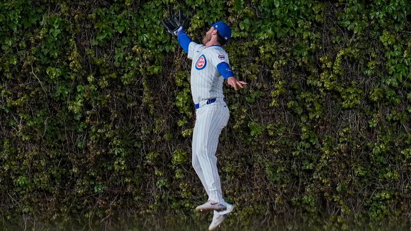 Chicago Cubs center fielder Cody Bellinger struggles to catch a fly ball from Houston Astros' Yainer Diaz as it bounces off the ivy during the fourth inning of a baseball game Tuesday, April 23, 2024, in Chicago. (AP Photo/Erin Hooley)