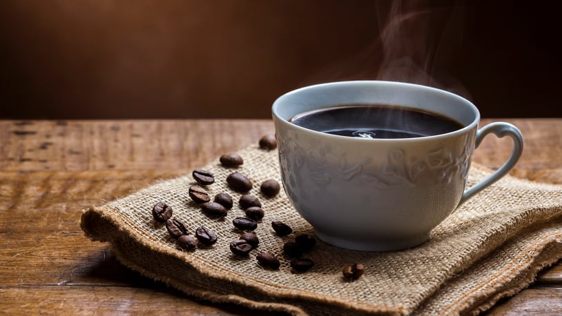 Cup of Steamy Coffee with smoke on wooden table