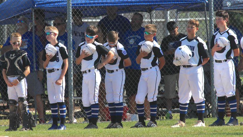 Hamilton West Side players stand for the national anthem before a game against Galion in the Little League state tournament on July 27, 2019, in New Albany. David Jablonski/Staff