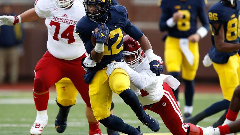 ANN ARBOR, MI - NOVEMBER 19: Chris Evans #12 of the Michigan Wolverines tries to escape the tackle of Marcus Oliver #44 of the Indiana Hoosiers during a first half run on November 19, 2016 at Michigan Stadium in Ann Arbor, Michigan. (Photo by Gregory Shamus/Getty Images)