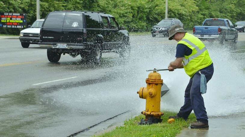 A Hamilton employee flushes a fire hydrant, a process in which crews check the hydrants. The flushing also clears water mains of sediment that can accumulate. PROVIDED