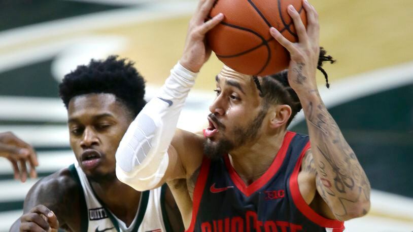 Ohio State guard Duane Washington Jr. drives to the basket against Michigan State guard Rocket Watts during the first half of an NCAA college basketball game Thursday, Feb. 25, 2021, in East Lansing, Mich. (AP Photo/Duane Burleson)
