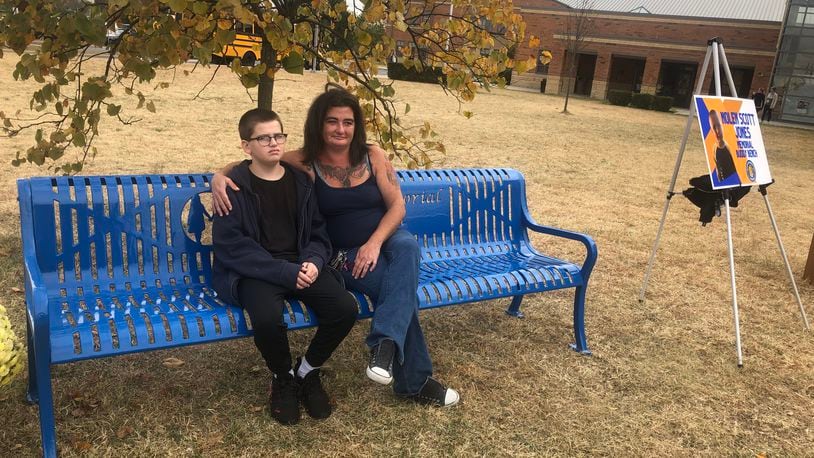 Mina Watson, 32, and her 13-year-old son, Logan Watson, sit on the Nolen Jones Memorial Buddy Bench that was dedicated Tuesday outside Linden Elementary School in Hamilton. Nolen, 6, a kindergartner at Linden, died of head injuries after he was struck by a car May 11, 2021 while crossing Pleasant Avenue. RICK McCRABB/STAFF