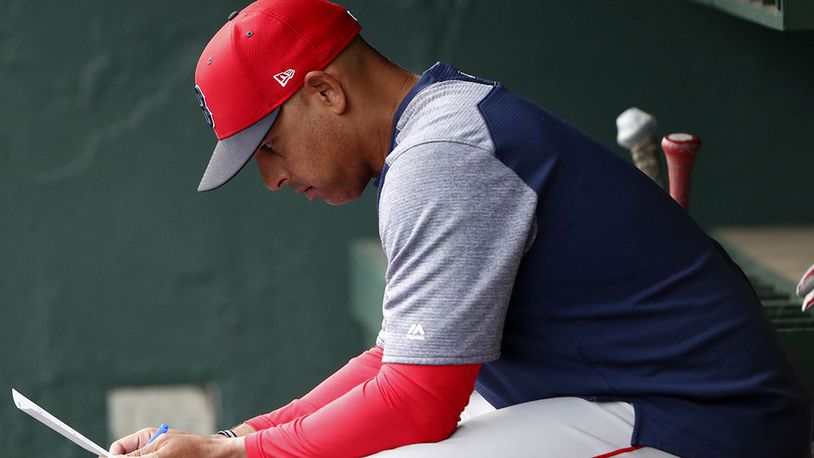 In this March 20, 2019, file photo, Boston Red Sox manager Alex Cora looks over the lineup before the team's spring training baseball game against the Baltimore Orioles in Sarasota, Fla. Cora was fired by the Red Sox on Tuesday, Jan. 14, 2020, a day after baseball Commissioner Rob Manfred implicated him in the sport's sign-stealing scandal.