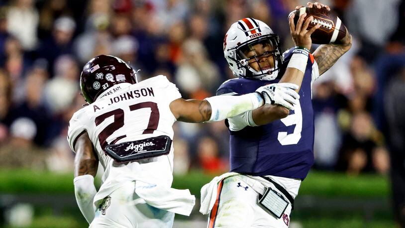 Auburn quarterback Robby Ashford (9) tries to elude a pursuit by Texas A&M defensive back Antonio Johnson (27) during the second half of an NCAA college football game Saturday, Nov. 12, 2022, in Auburn, Ala. (AP Photo/Butch Dill)