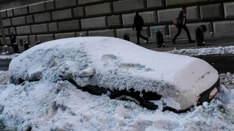 FILE PHOTO: A car is buried in the plowed snow in the Financial District, January 5, 2018 in New York City.