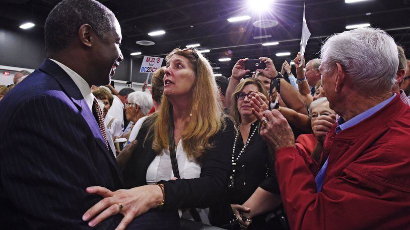 Republican presidential candidate Dr. Ben Carson greets Marjorie Pitzer in the front row after a campaign rally Tuesday at the Sharonville Convention Center.