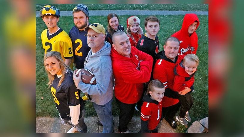 The entire family of Harlie Ray, center left, and his brother, Larry, stands divided over the Ohio State/Michigan rivalry. BILL LACKEY/STAFF