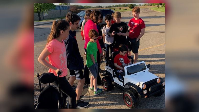 Kyle Robertson received his car in May and adjusted to it while his mother, Pamela Ollish, was being shown how to use the emergency stop switch by members of the geometry class which built it for him. CONTRIBUTED