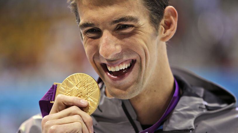 Michael Phelps displays his gold medal for the men's 100-meter butterfly swimming final at the Aquatics Centre in the Olympic Park during the 2012 Summer Olympics in London. Matt Slocum/Associated Press