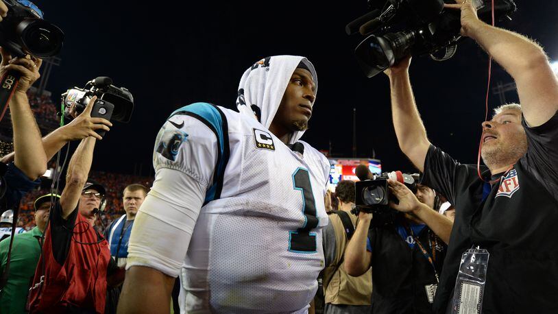 DENVER, CO - SEPTEMBER 8:  Quarterback Cam Newton #1 of the Carolina Panthers walks off the field surrounded by reporters after a 21-20 loss to the Denver Broncos at Sports Authority Field at Mile High on September 8, 2016 in Denver, Colorado. (Photo by Dustin Bradford/Getty Images)