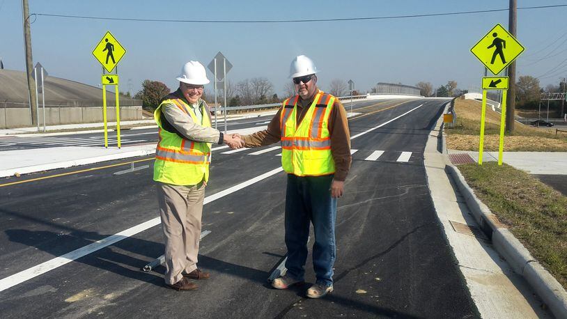 Warren County Engineer Neil Tunison shakes hands with Project Inspector Jeff Jones at the completed Socialville-Fosters Bridge over Interstate 71. CONTRIBUTED