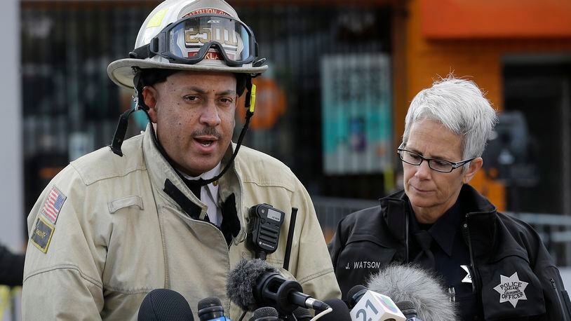 Oakland fire deputy chief Darren White, left, speaks next to Oakland Police officer Joanna Watson at a news conference near the site of a warehouse fire in Oakland, Calif., Tuesday, Dec. 6, 2016. The fire erupted Friday, Dec. 2, killing dozens. (AP Photo/Jeff Chiu)