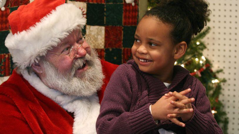 Olivia Albrecht, 6, laughs as she tells Santa what she wants in 2009 at the Santa House in Hamilton. The Santa House will open for the 2018 Christmas season on Dec. 1.