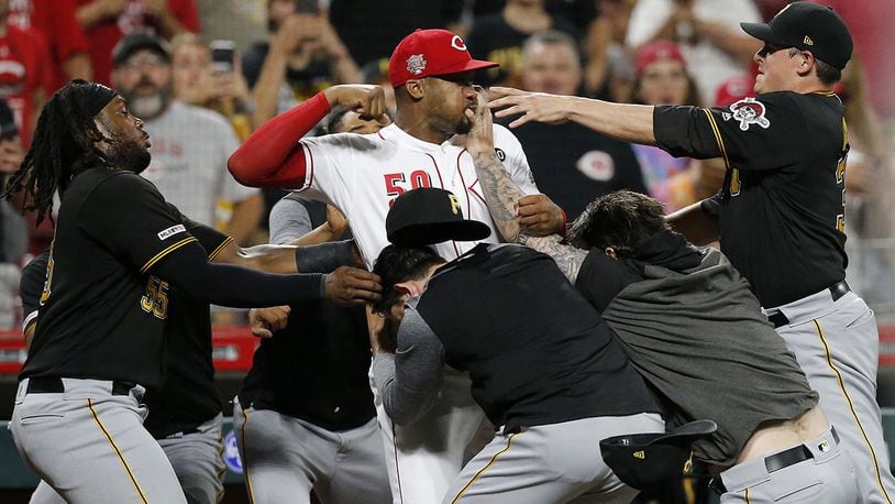 Cincinnati Reds relief pitcher Amir Garrett (50) looks to throw a punch as he is held back by a number of Pittsburgh Pirates players during a brawl in the ninth inning of a baseball game in Cincinnati on Tuesday, July 30, 2019.