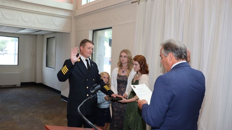Hamilton Fire Chief Thomas Eickelberger, with daughters Maggie, Wrenlie and June, is sworn in by Public Safety Director Scott Scrimizzi. HAMILTON FIRE DEPARTMENT