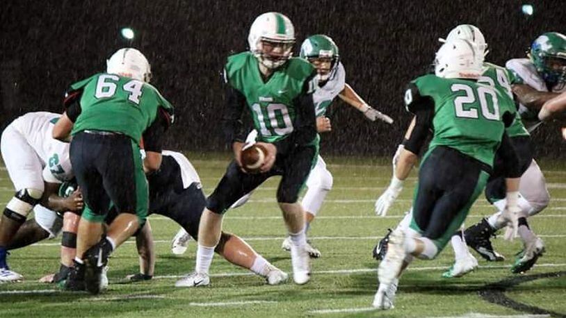 Badin’s Zach Switzer (10) is about to hand off to Alex DeLong (20) as Andrew Jones (64) provides some blocking in last Friday night’s 38-21 triumph over Chaminade Julienne at Fairfield Stadium in Fairfield. CONTRIBUTED PHOTO BY TERRI ADAMS