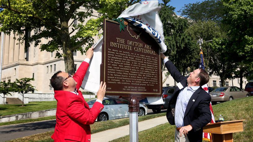 Michael Roediger, director and CEO of the Dayton Art Institute (left), and Brock Anderson III, chair of the board of trustees, unveil an Ohio Historical Marker commemorating the 100th year of the Dayton Art Institute on Tuesday, July 2. LISA POWELL / STAFF