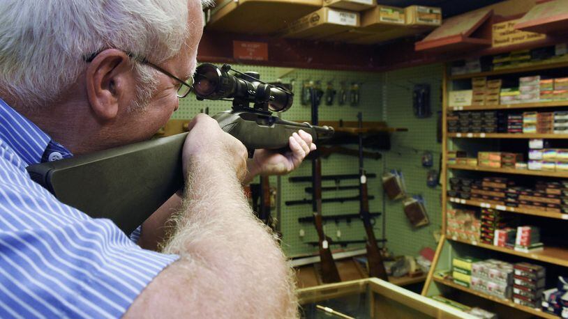 David Rhea looks through the scope of a gun at Roberson’s Sporting Goods Monday morning in Madison Twp. New legislation introduced in the House of Representatives would require a person to carry liability insurance before being allowed to purchase a gun. This is the second time the The Firearm Risk Protection Act has been introduced by U.S. Rep. Carolyn Maloney, D-New York.