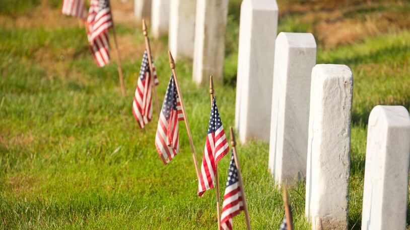 American flags  are placed near gravestones at Arlington National Cemetery in Virginia