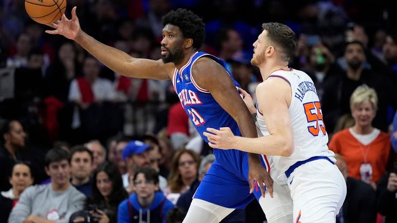 Philadelphia 76ers' Joel Embiid, left, reaches for a pass against New York Knicks' Isaiah Hartenstein during the first half of Game 3 in an NBA basketball first-round playoff series, Thursday, April 25, 2024, in Philadelphia. (AP Photo/Matt Slocum)