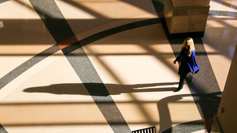 A woman walks through the morning shadows in the Government Services Center in Hamilton. Butler County is back on the hunt for a new assistant county administrator since their interim person is returning to the Water and Sewer Department. GREG LYNCH/2016