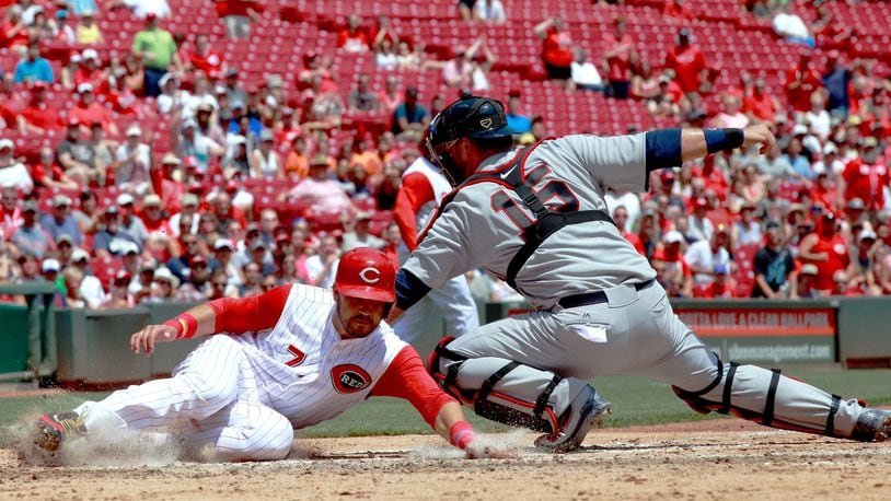 July 16 will be the city of Hamilton’s day to see the Cincinnati Reds at Great American Ball Park. Here, The Reds’ Eugenio Suarez, left, slides past the tag of Braves catcher A.J. Pierzynski and scores last season. DAVID JABLONSKI/STAFF