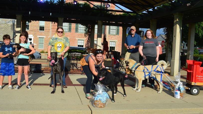 Prize winners of the Dog Days judging during the Red Brick Friday contest gathered for a photo. Shown above (from left) are Lou, winner of the shortest dog award at 10 inches; Marley, the tallest dog at 35 inches; Severus, best costume winner dressed as a lion; and Asil, one of two dogs pulling the Pupweiser wagon, winner of the longest tail, at 20 inches. In back is Mayor Bill Snavely who served as judge. CONTRIBUTED/BOB RATTERMAN