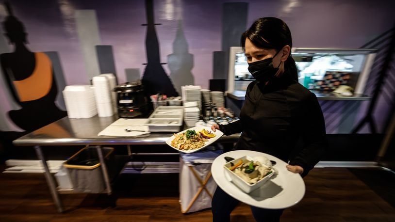 Thai Table manager, Pom Hmornvattanavong, serves food March 14, 2022. Two years ago, Ohio shut down bars and indoor dining for two-and-a-half months in hopes of stopping the spread of COVID-19. JIM NOELKER/STAFF