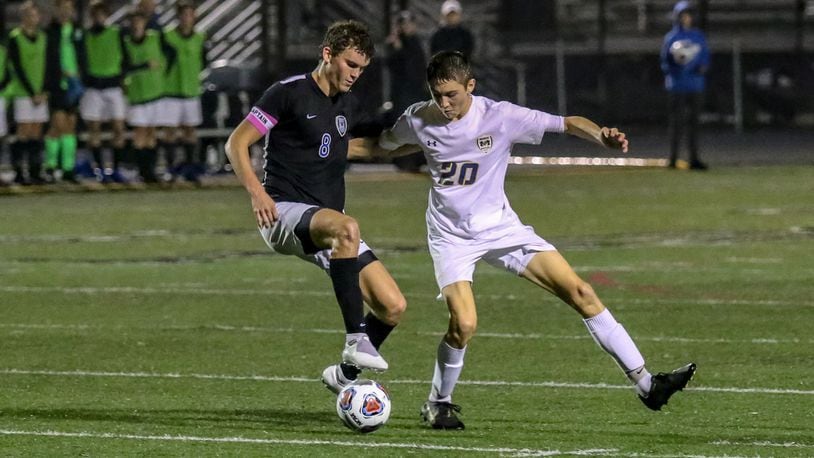 Monroe High School junior Adam Ploeger (right) and Cincinnati Wyoming’s Jesse Levine tussle for the ball during their Division II regional semifinal match on Wednesday night at Lakota East High School. Wyoming won 1-0. CONTRIBUTED PHOTO BY MICHAEL COOPER