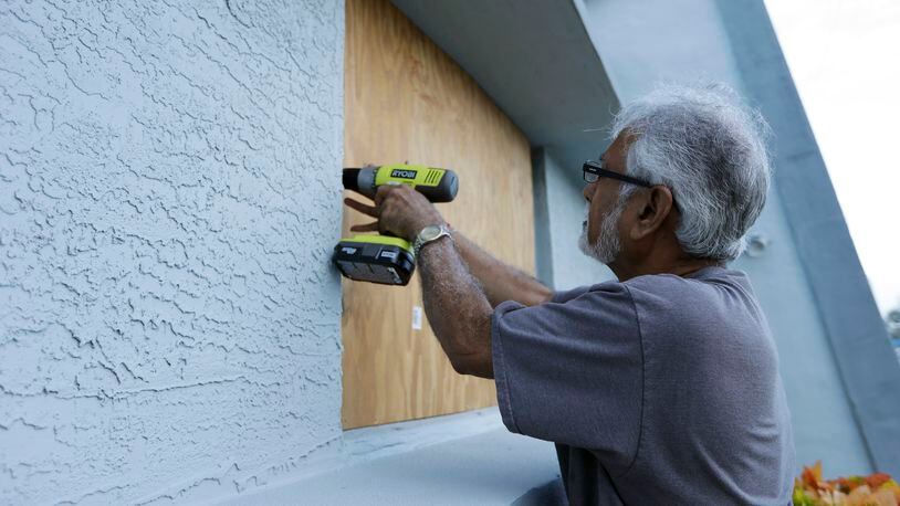 Ray Gohill, owner of the Sahara Motel, does some last minute boarding up of his windows Thursday, Oct. 6, 2016, in Daytona Beach, Fla. Hurrican Matthew continues to make a path for Florida's east coast. (AP Photo/Chris O'Meara)