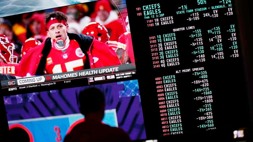 FILE PHOTO: A person gambles as betting odds for NFL football's Super Bowl are displayed on monitors at the Circa resort and casino sports book Friday, Feb. 3, 2023, in Las Vegas. (AP Photo/John Locher)