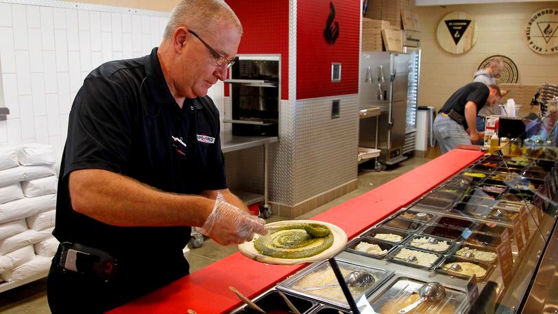 Ray Wiley, president and CEO of Rapid Fired Pizza, creates a pizza. The restuarant recently announced it will open inside at least one Kroger store. LISA POWELL / STAFF